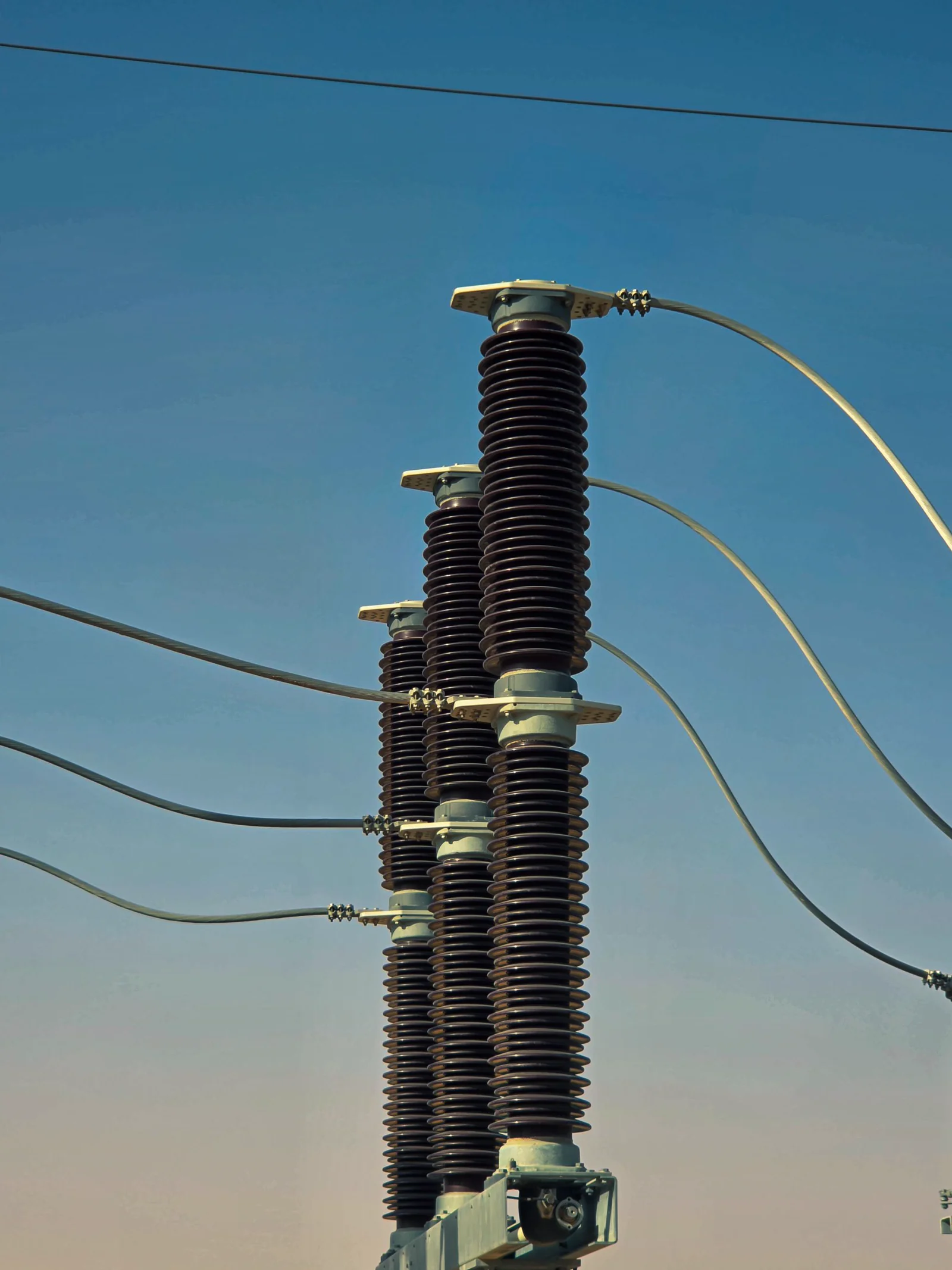 Close-up of ceramic high-voltage insulators against a clear sky