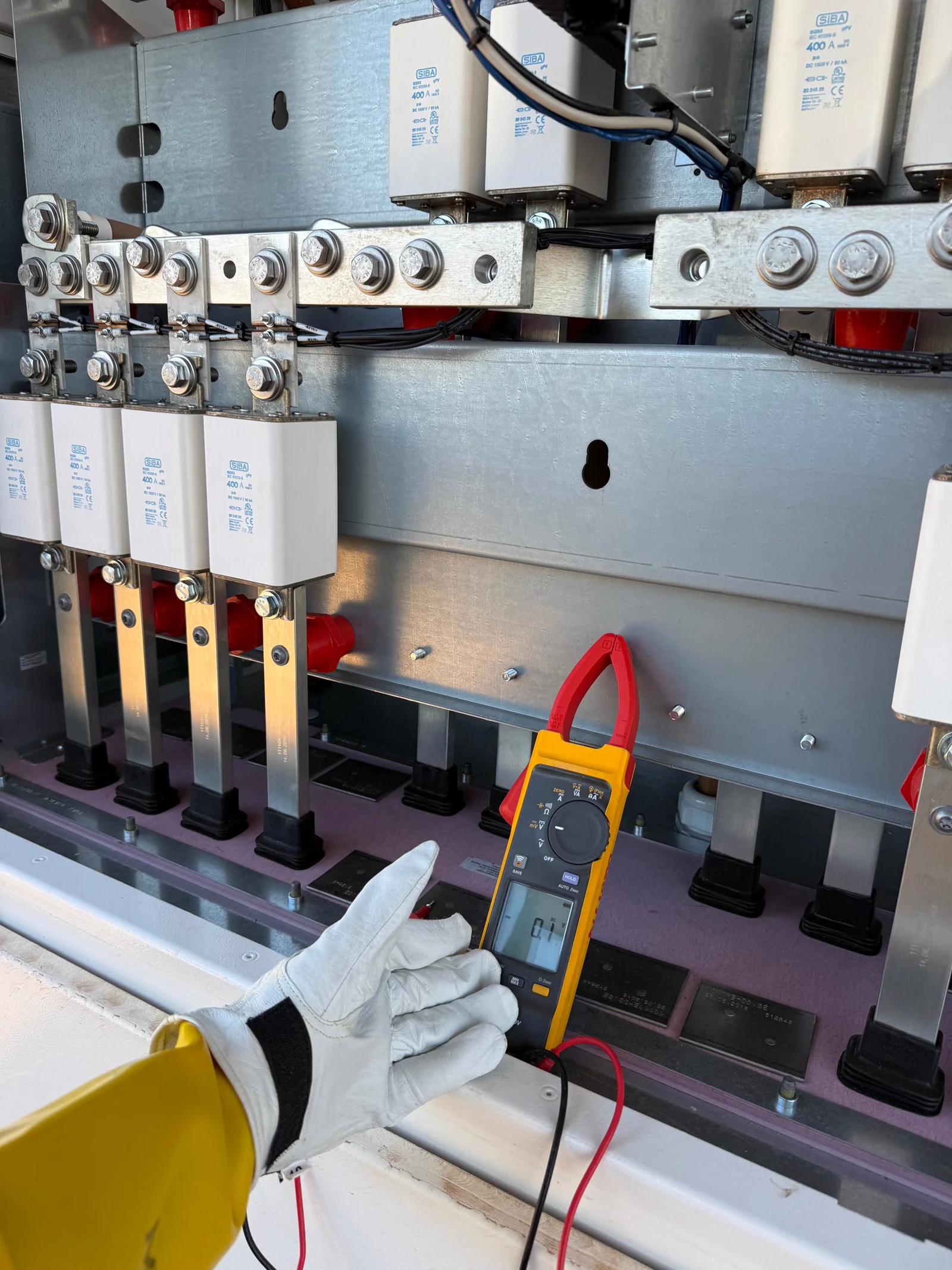 Technician measuring voltage on an outdoor electrical panel