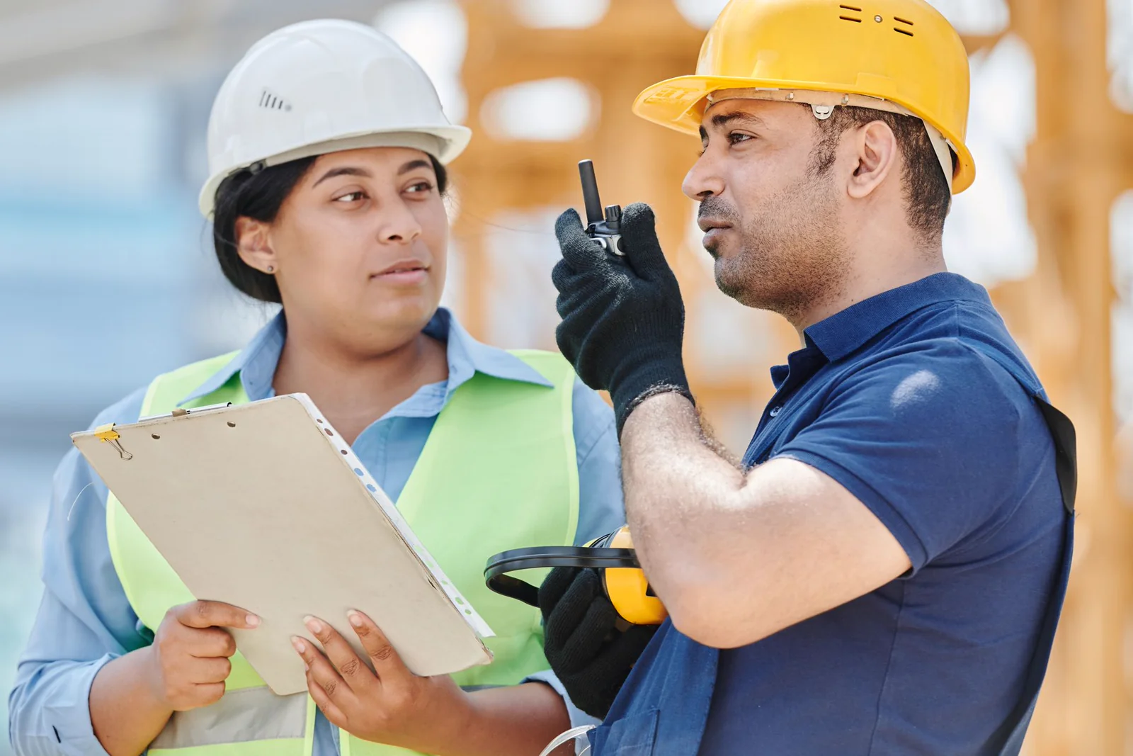 Two engineers in hard hats discussing a project on site