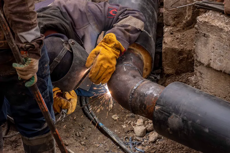 Close-up of a welder working a steel pipe joint