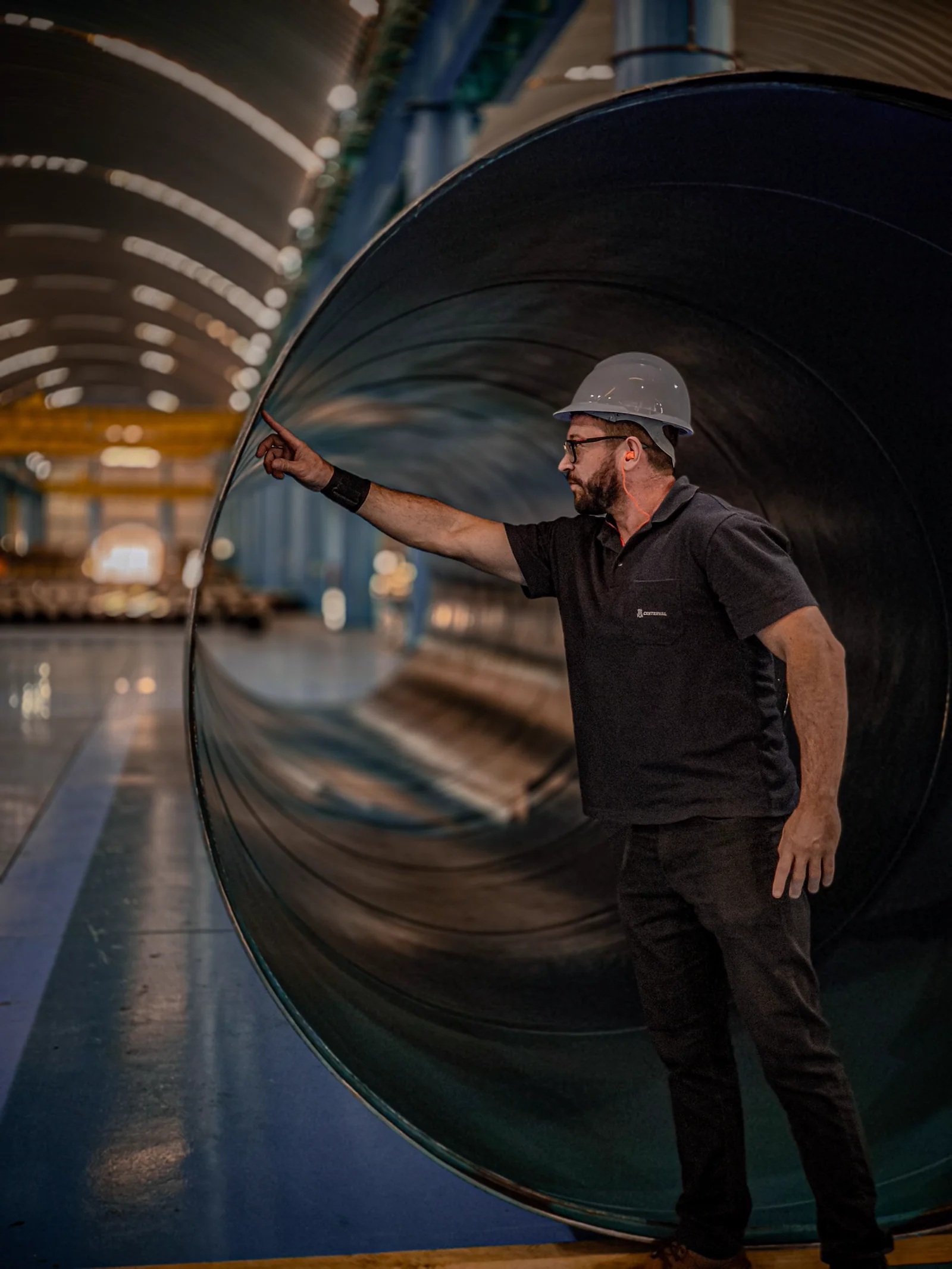 Engineer evaluating a large pipe segment during a coating specification review