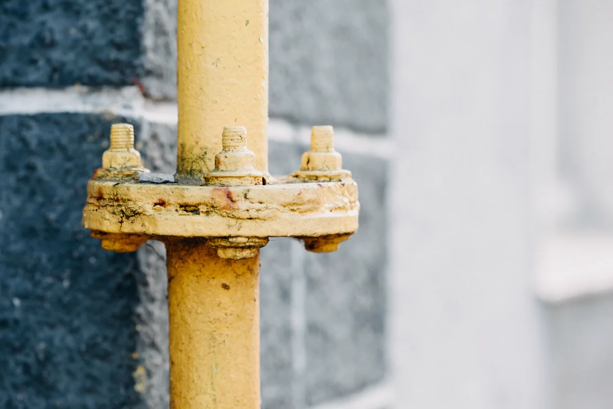 Close-up of a weathered yellow gas distribution pipe