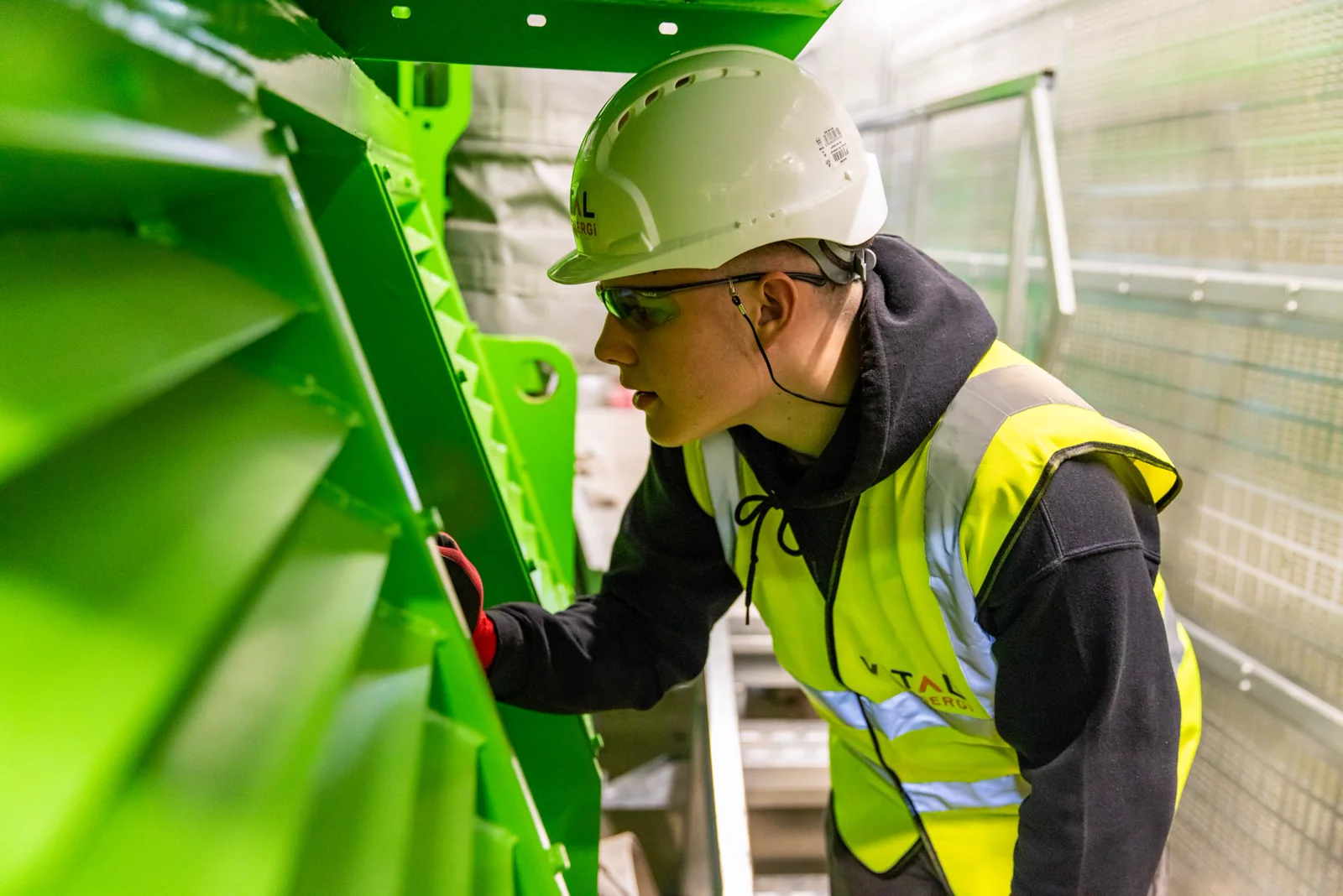 Worker inspecting industrial machinery at a facility