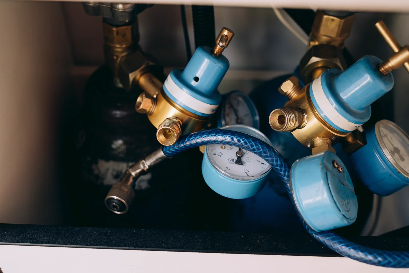 Close-up of gas pressure regulators, gauges, and tubing on an industrial skid